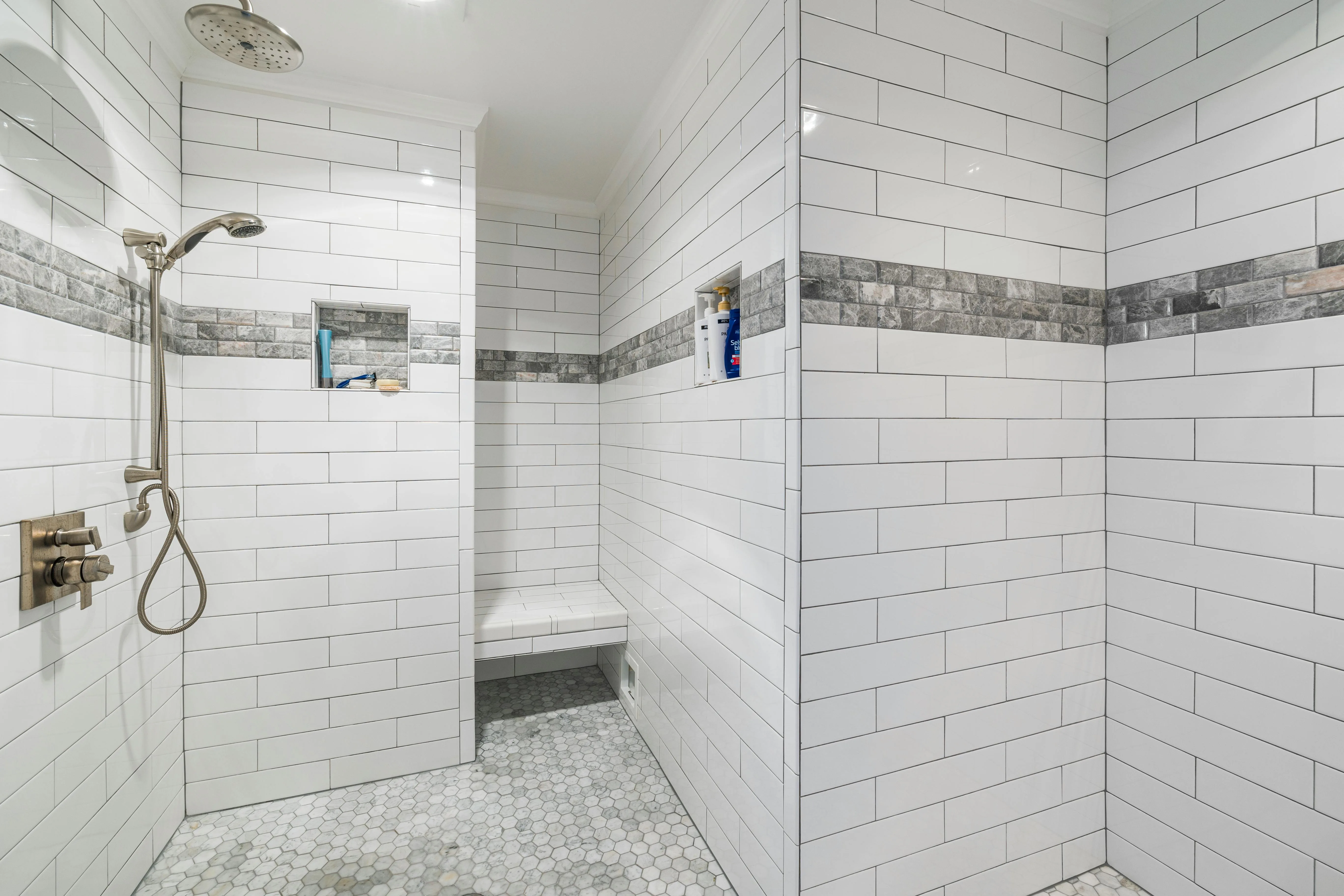 White subway tile shower with decorative accent tile band