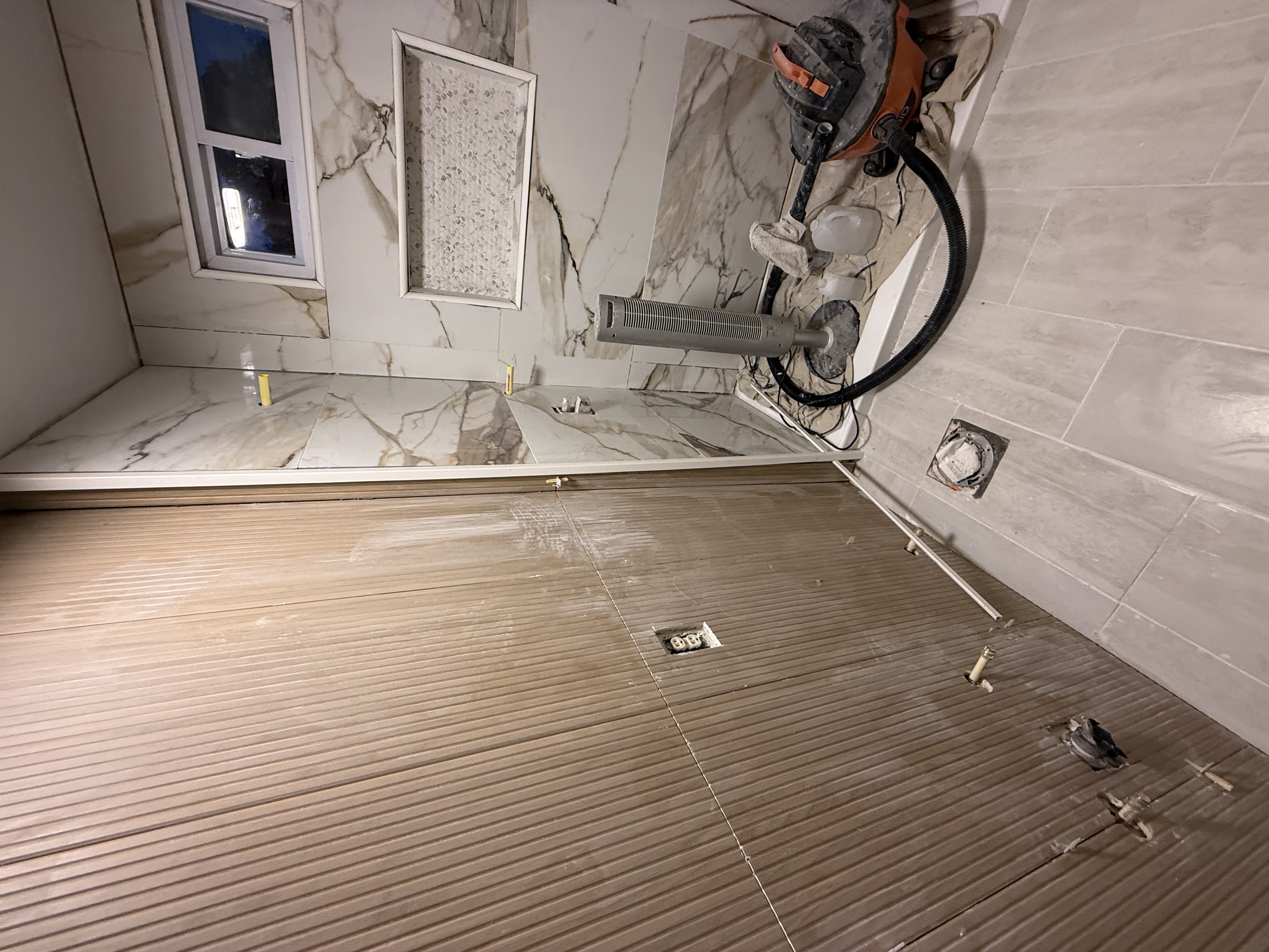 Large-format tile installation in progress with clip system for lippage control